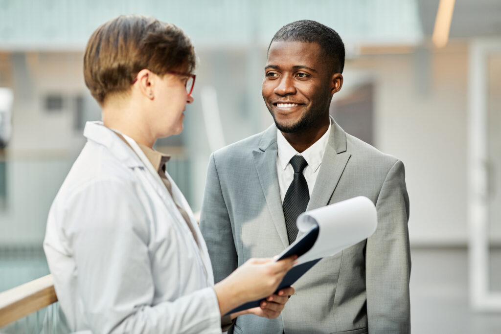 A public health professional talks to a colleague in a corridor