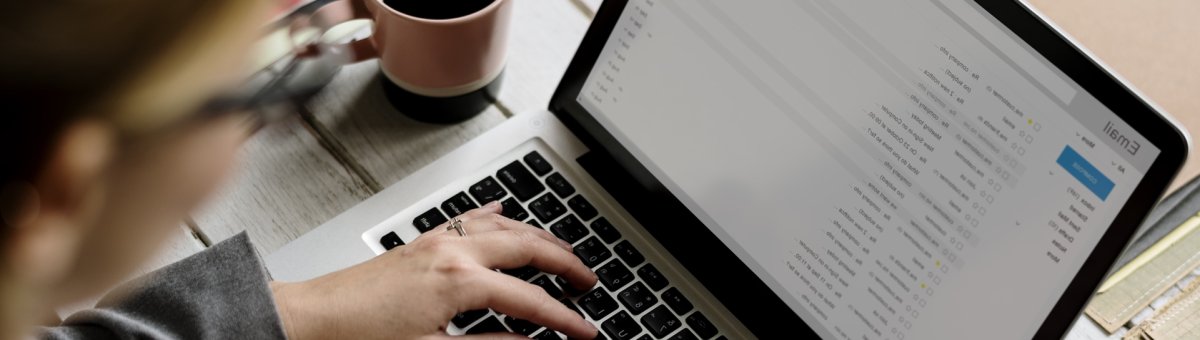 A persons hand typing on a laptop computer.