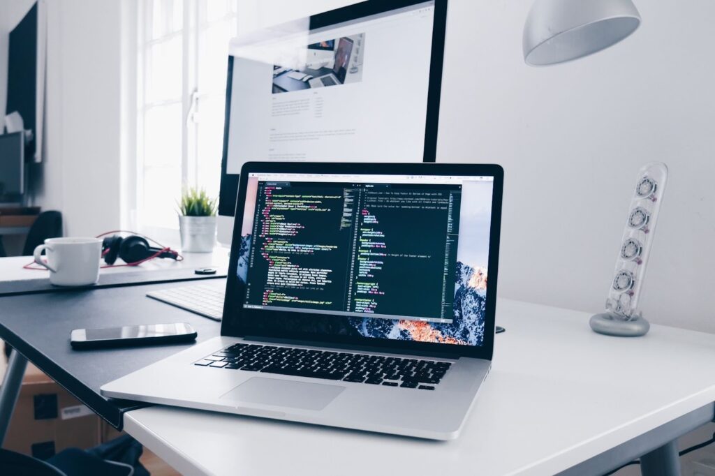 An open laptop on a desk with a code editing tool open on the display.
