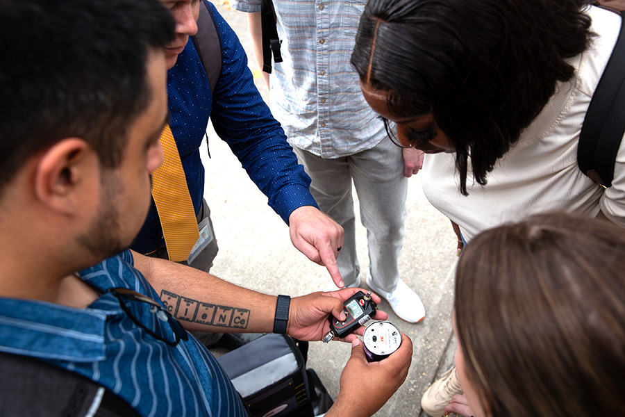 Rustin Reed looks at a metering device with environmental health students