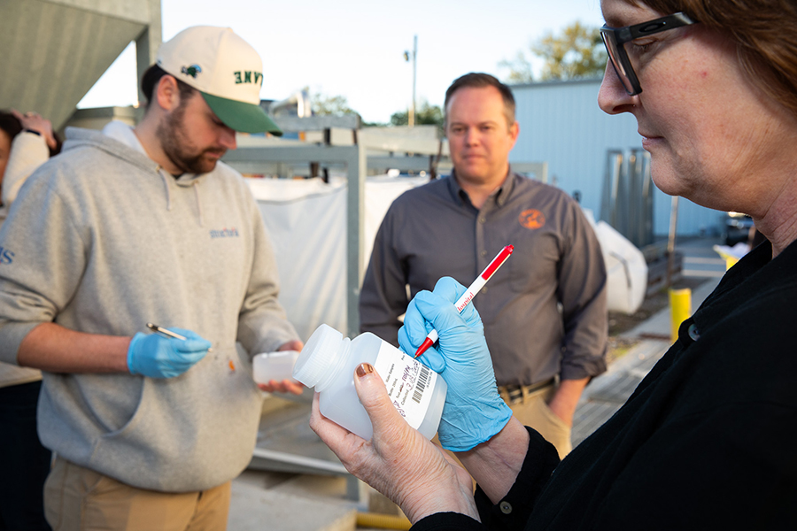 Industrial hygienists labeling containers of liquid