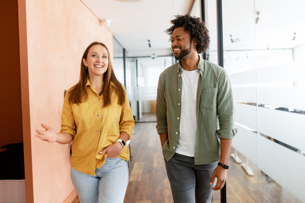 People walking, smiling, and talking in a hallway.