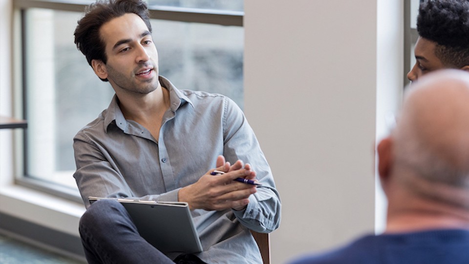 A man has a conversation with two other men