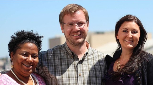Three Tulane social work students smile together with a clear blue sky in the background