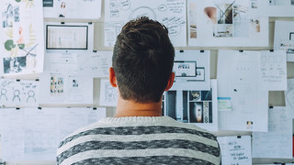 The back of a person looking at a panel with multiple papers on it