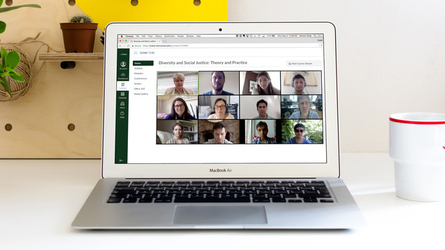 A laptop computer screen shows a group of Tulane social work students meeting together for class online