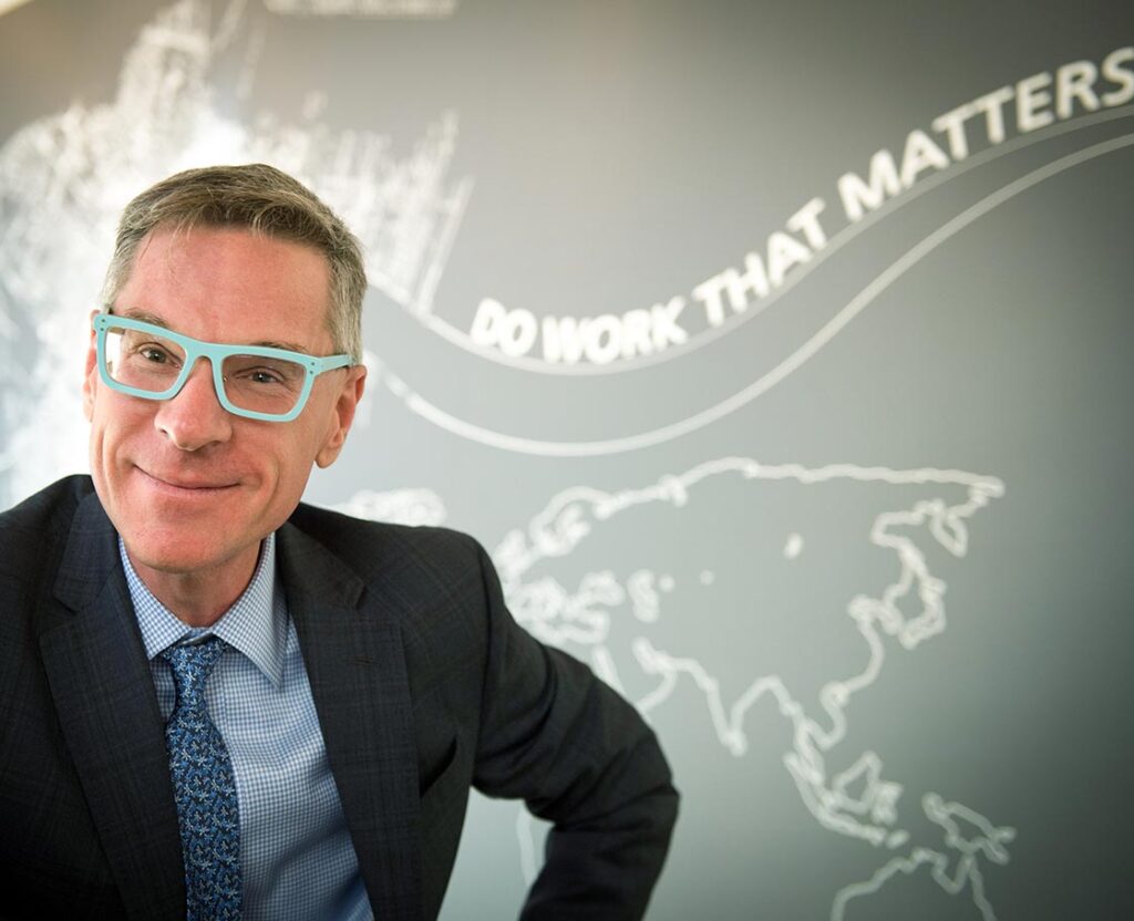 The Dean of Tulane University's School of Social Work in front of a graphic that says, "Do Work That Matters"