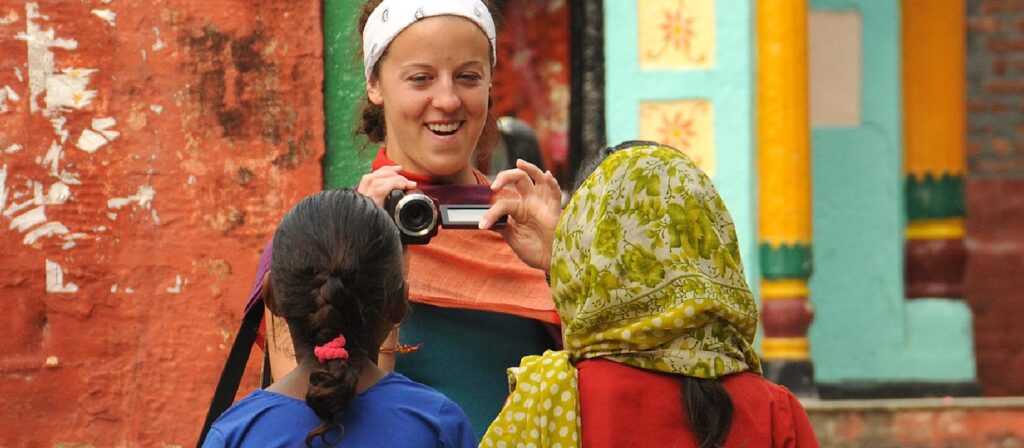 A Tulane University student takes a photo of two young girls